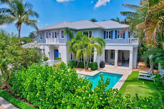 rear view of house featuring a patio and a balcony