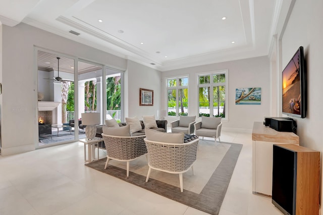 dining space with a raised ceiling, ceiling fan, and ornamental molding