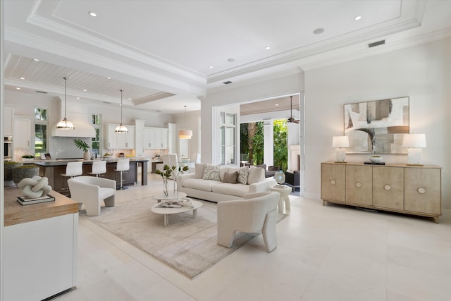 living room with a raised ceiling and ornamental molding