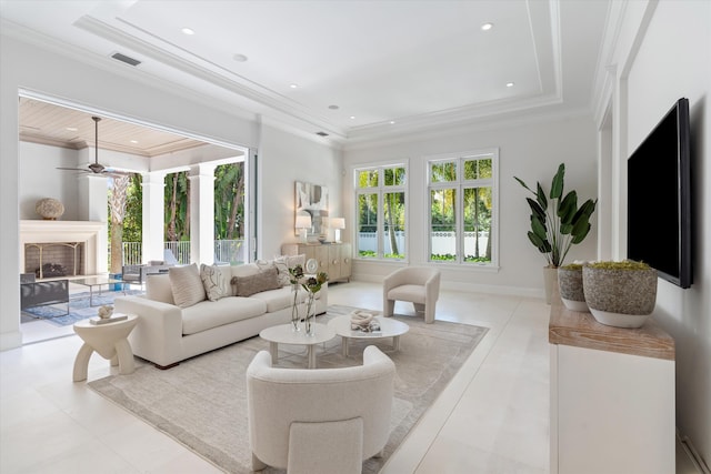 living room featuring light tile patterned floors, crown molding, a raised ceiling, and ceiling fan