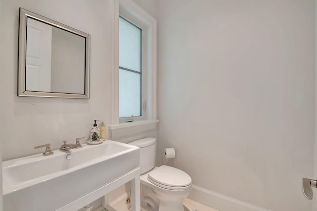 bathroom featuring a healthy amount of sunlight, toilet, and sink