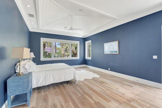 bedroom with crown molding, vaulted ceiling, and light wood-type flooring