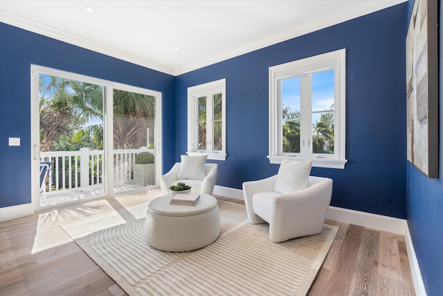 living area with ornamental molding and wood-type flooring