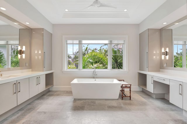 bathroom featuring vanity, a healthy amount of sunlight, and a tray ceiling