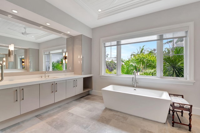 bathroom featuring vanity, a bathtub, crown molding, and ceiling fan