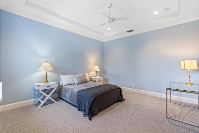 carpeted bedroom featuring ornamental molding, ceiling fan, and a tray ceiling