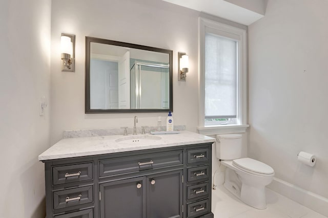 bathroom featuring toilet, vanity, tile patterned floors, and a shower with shower door