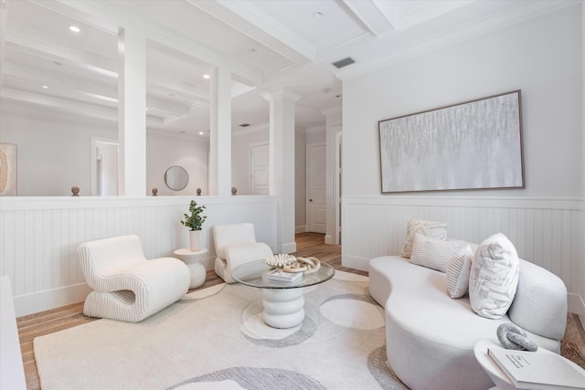 sitting room featuring coffered ceiling, ornate columns, crown molding, light hardwood / wood-style flooring, and beamed ceiling