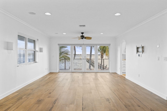 unfurnished living room with crown molding, plenty of natural light, and light hardwood / wood-style floors