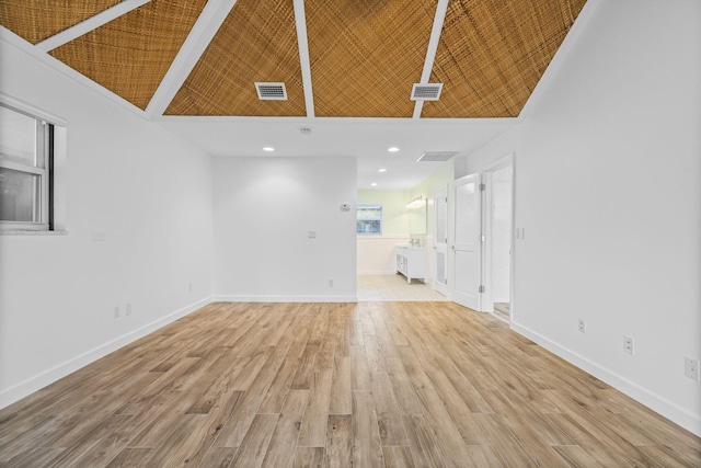 unfurnished living room with beam ceiling, high vaulted ceiling, and light hardwood / wood-style floors