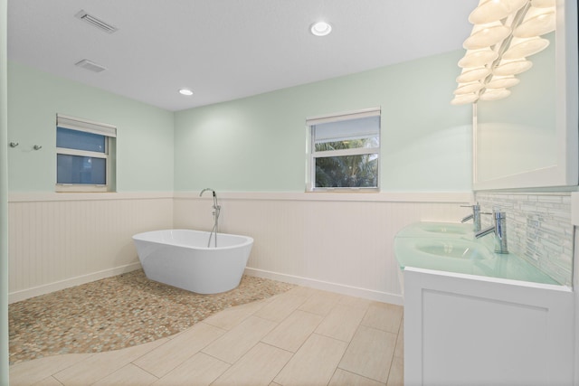 bathroom with vanity and a tub