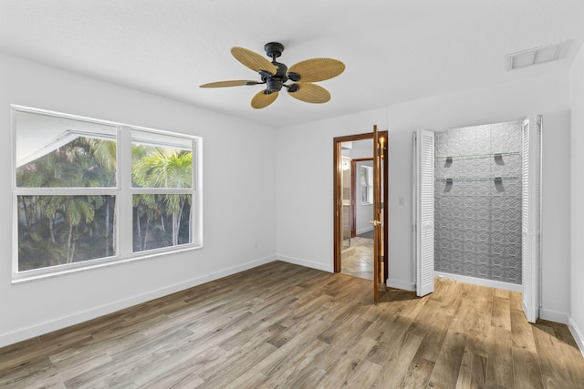 unfurnished bedroom featuring ceiling fan, light wood-type flooring, and a closet