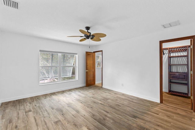 spare room with ceiling fan and light wood-type flooring