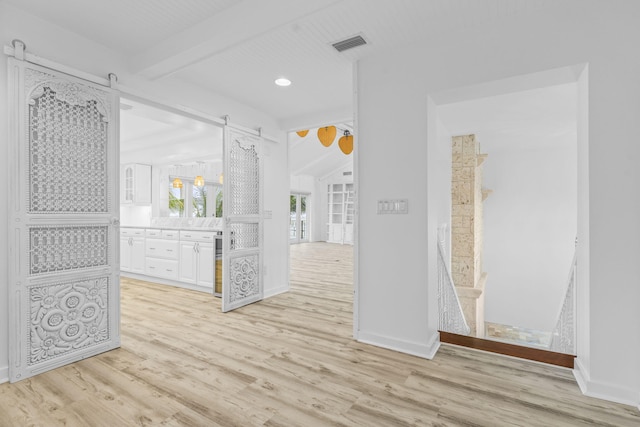 hallway with beam ceiling and light hardwood / wood-style flooring