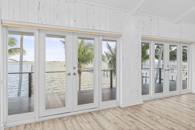 entryway with wood walls, french doors, and a water view