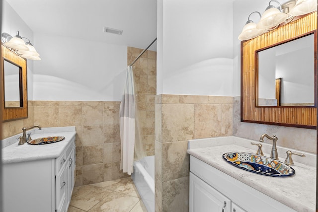 bathroom with tile patterned floors, vanity, shower / bath combination with curtain, and tile walls