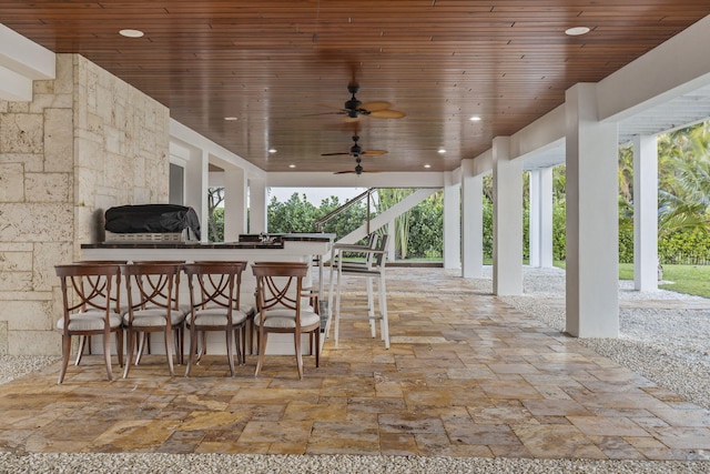 view of patio with ceiling fan and an outdoor bar