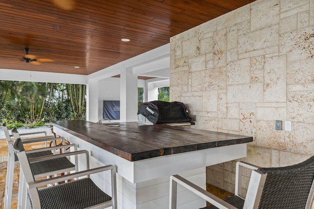 view of patio with ceiling fan, a grill, and an outdoor bar