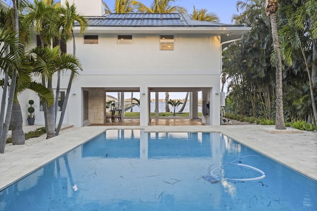 view of swimming pool with a patio area and a water view