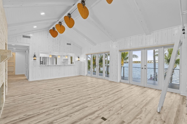 unfurnished living room featuring french doors, light wood-type flooring, a water view, high vaulted ceiling, and beamed ceiling