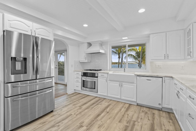 kitchen with stainless steel appliances, white cabinetry, and custom exhaust hood