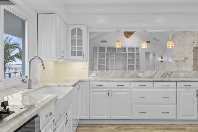 kitchen with decorative backsplash, white cabinetry, and light wood-type flooring