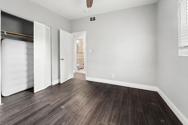 unfurnished bedroom featuring ceiling fan, a closet, and dark wood-type flooring