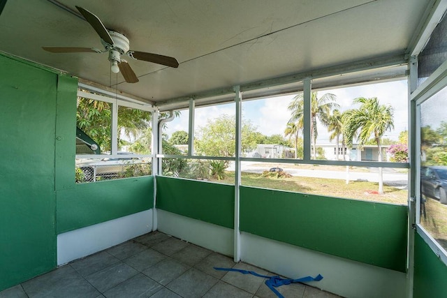 unfurnished sunroom featuring ceiling fan