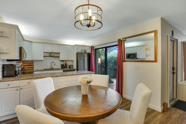 dining area featuring light hardwood / wood-style floors, sink, and a chandelier