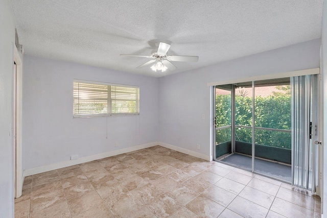 unfurnished room with ceiling fan and a textured ceiling