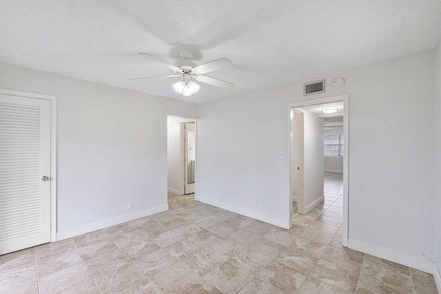 empty room with a textured ceiling and ceiling fan