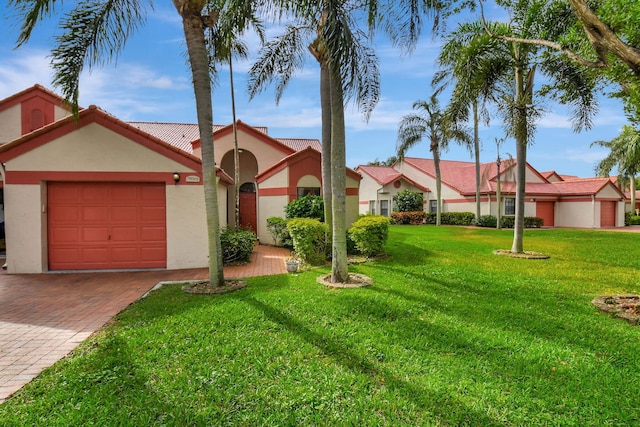 7906 Lexington Club Blvd Unit B, Delray Beach, FL 33446 - view of front of home featuring stucco siding, a garage, a front yard, a tiled roof, and decorative driveway