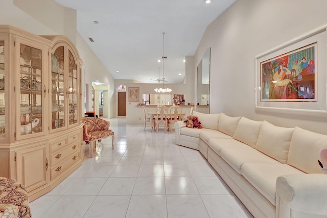 living room with light tile patterned floors, a towering ceiling, and a notable chandelier