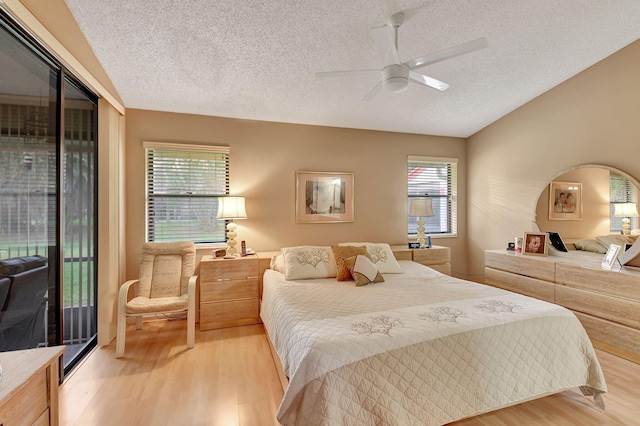 bedroom featuring access to exterior, ceiling fan, light hardwood / wood-style flooring, and a textured ceiling