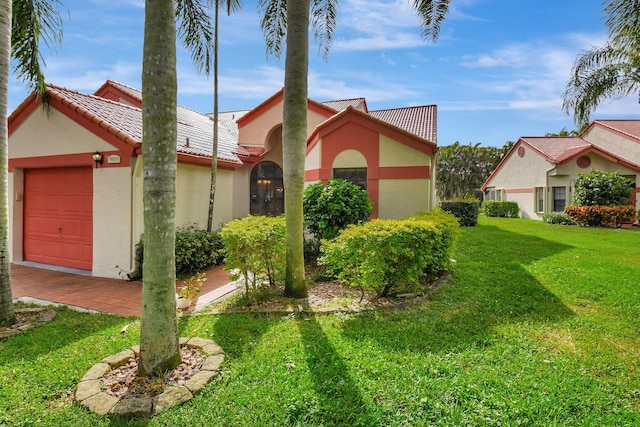 mediterranean / spanish house with a front lawn and a garage