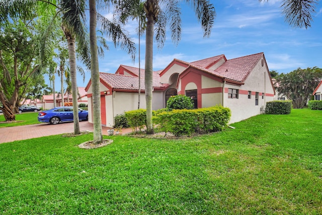 7906 Lexington Club Blvd Unit B, Delray Beach, FL 33446 - view of front of house featuring a front lawn, stucco siding, decorative driveway, and a tiled roof