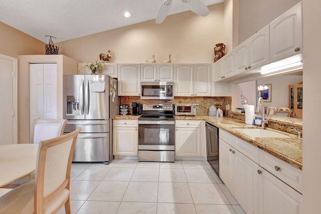 7906 Lexington Club Blvd Unit B, Delray Beach, FL 33446 - kitchen featuring stainless steel appliances, backsplash, light stone countertops, white cabinetry, and high vaulted ceiling