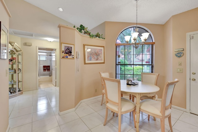 tiled dining room featuring a notable chandelier, lofted ceiling, and a textured ceiling