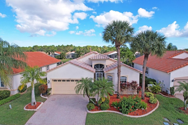 mediterranean / spanish-style house featuring a front lawn and a garage