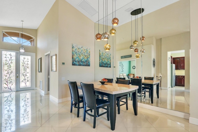 tiled dining area featuring french doors and a towering ceiling