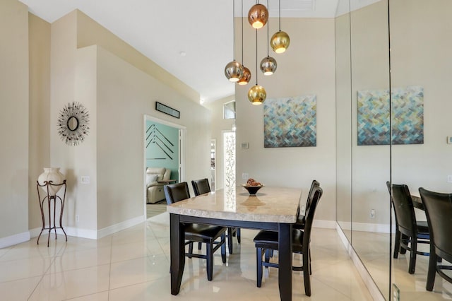 dining space featuring light tile patterned floors and vaulted ceiling