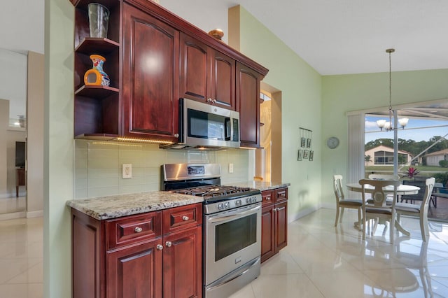 kitchen with appliances with stainless steel finishes, light stone counters, pendant lighting, a chandelier, and lofted ceiling