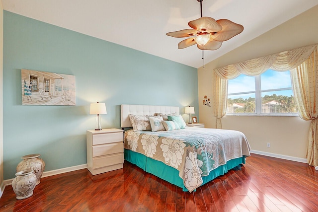 bedroom with ceiling fan, dark wood-type flooring, and vaulted ceiling