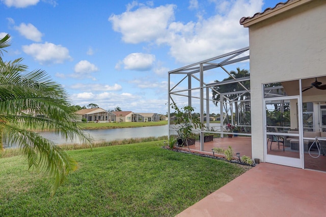 view of yard featuring a lanai, a patio area, and a water view