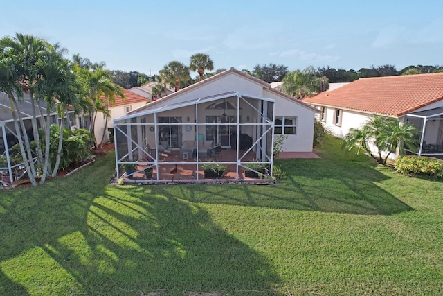 back of property with a patio, a lanai, and a lawn