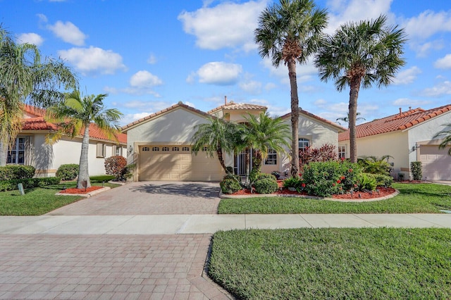 mediterranean / spanish home featuring a garage and a front lawn