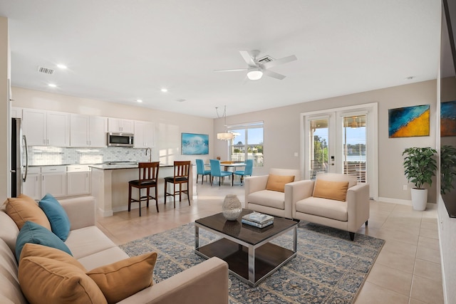 living room featuring ceiling fan, french doors, and light tile patterned floors