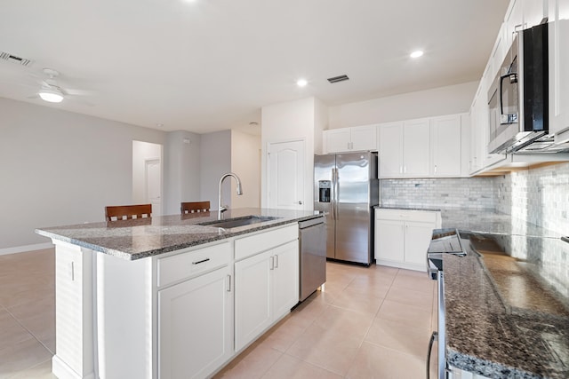 kitchen featuring white cabinets, a kitchen island with sink, and stainless steel appliances