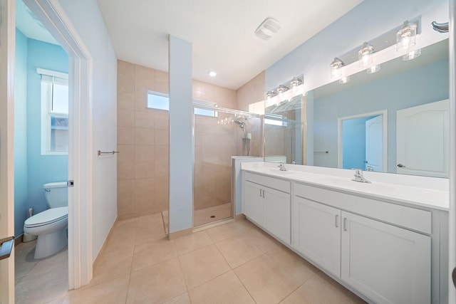 bathroom with tile patterned floors, vanity, an enclosed shower, and toilet