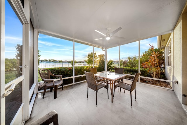 sunroom with a water view and ceiling fan